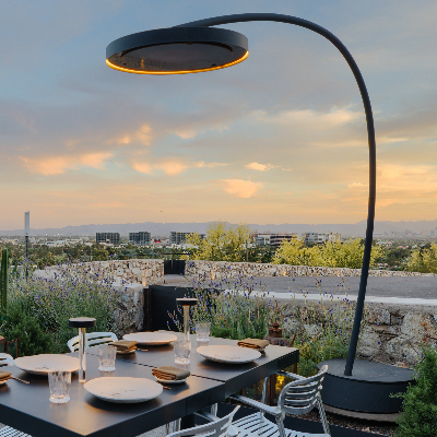 Bromic Eclipse Freestanding heater beside an outdoor dining table at sunset